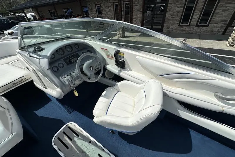 Slide: The Image of 1994 Sea Ray 220 Overnighter Signature boat interior with white seating and dashboard controls. - 19