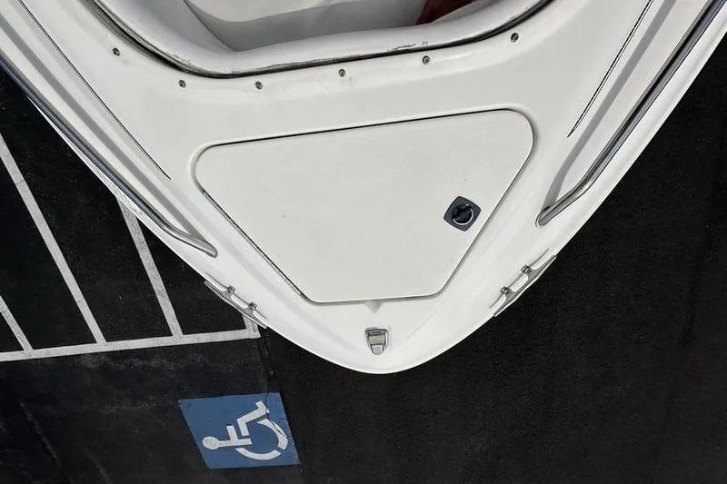 Slide: The Image of Bow of a 1994 Sea Ray 220 Overnighter Signature boat near a handicap parking space. - 21