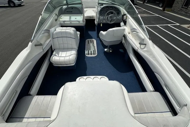 Slide: The Image of 1994 Sea Ray 220 Overnighter Signature boat interior with white seating and blue carpet. - 3
