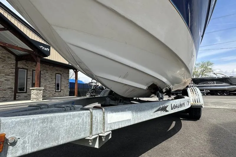 Slide: The Image of 1994 Sea Ray 220 Overnighter Signature boat on trailer, parked outside a building. - 5