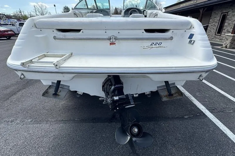 Slide: The Image of Rear view of a 1994 Sea Ray 220 Overnighter Signature boat in a parking lot. - 6