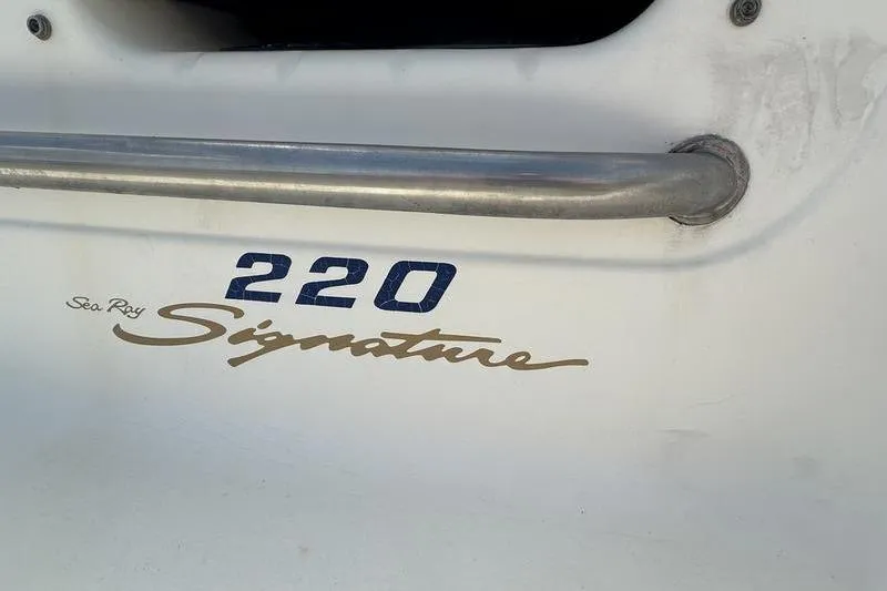 Slide: The Image of 1994 Sea Ray 220 Overnighter Signature boat logo and railing detail. - 8
