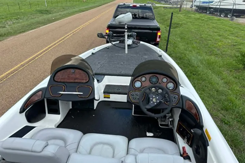 Slide: The Image of 2001 Triton Tr-21 Executive DC boat interior with steering wheel and dashboard on a road. - 3