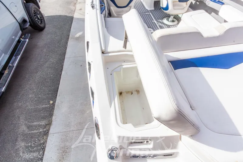Slide: The Image of 2012 Chaparral 226 SSi boat interior with white seating and storage compartment. - 12
