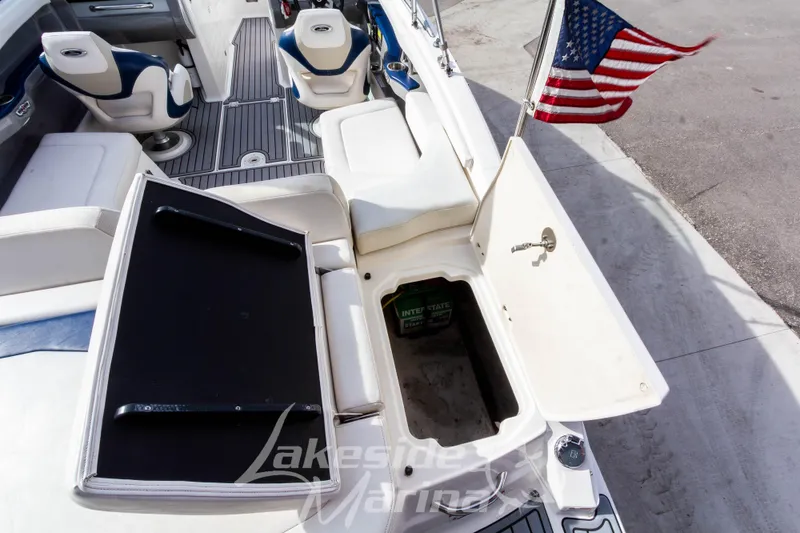 Slide: The Image of 2012 Chaparral 226 SSi boat interior with open storage compartment and American flag. - 15