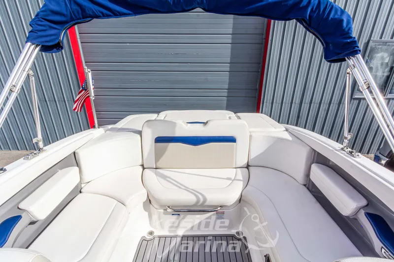 Slide: The Image of 2012 Chaparral 226 SSi boat interior with white and blue seating, American flag visible. - 17
