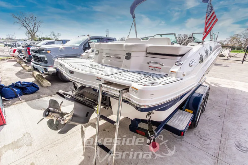 Slide: The Image of 2012 Chaparral 226 SSi boat on trailer, parked at marina with American flag. - 4