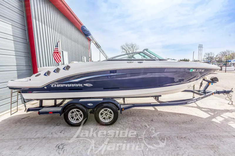 Slide: The Image of 2012 Chaparral 226 SSi boat on trailer, parked outdoors near a marina. - 6