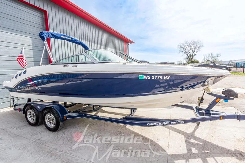 Slide: The Image of 2012 Chaparral 226 SSi boat on trailer, parked outside a marina building. - 7