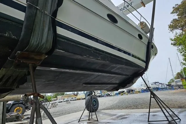 Slide: The Image of 1999 Doral 360se boat on stands in a shipyard, underside view. - 10
