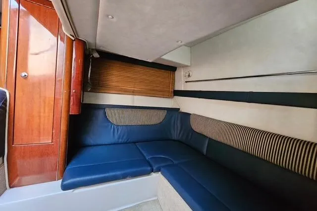 Slide: The Image of Interior of a 1999 Doral 360se boat with blue seating and wood accents. - 11