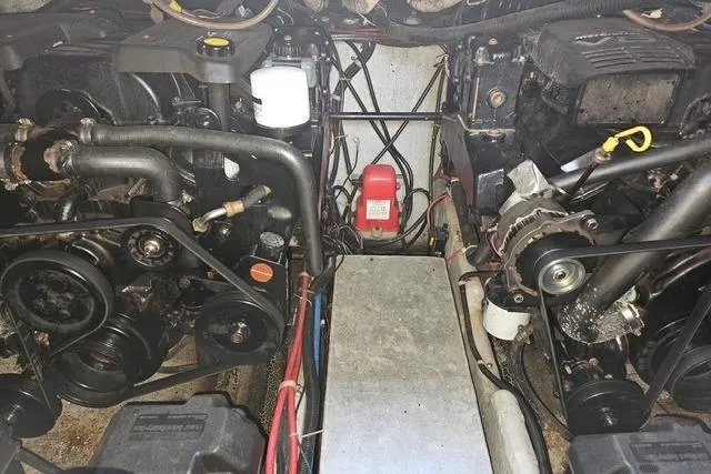 Slide: The Image of Engine compartment of a 1999 Doral 360se boat, showing dual engines and components. - 15