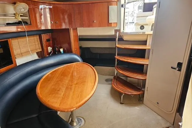 Slide: The Image of Interior of a 1999 Doral 360se yacht with wooden table and curved seating. - 7