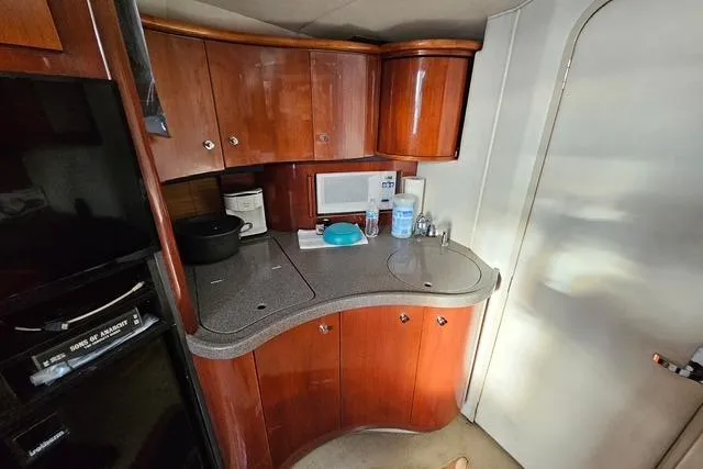 Slide: The Image of 1999 Doral 360se yacht kitchen with wooden cabinets, microwave, and countertop appliances. - 9