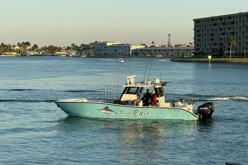 The Image of 2023 Insetta 35 IFC boat cruising on a calm waterway near coastal buildings. - 1