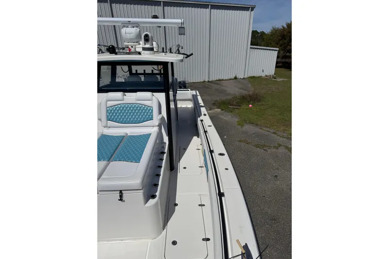 Slide: The Image of 2023 Insetta 35 IFC boat with blue seating, docked near a metal building. - 5