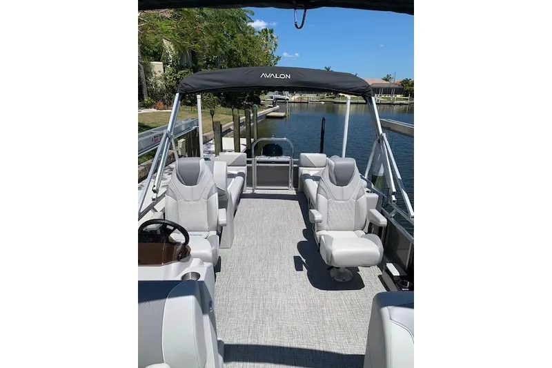 Slide: The Image of 2025 Avalon 2585 Venture QL Tri-Toon boat with luxurious seating on a sunny day. - 5