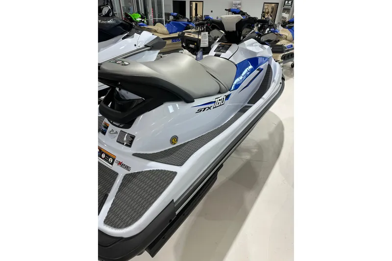 Slide: The Image of 2024 Kawasaki JN1500CRFNN jet ski in showroom, featuring sleek design and blue accents. - 4