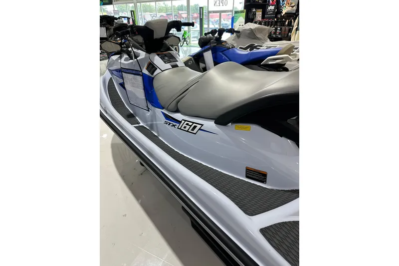 Slide: The Image of 2024 Kawasaki JN1500CRFNN jet ski, white and blue, displayed in showroom. - 5