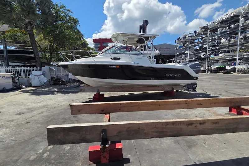 Slide: The Image of 2008 Robalo R265 Walkaround boat on dry dock under a clear blue sky. - 3