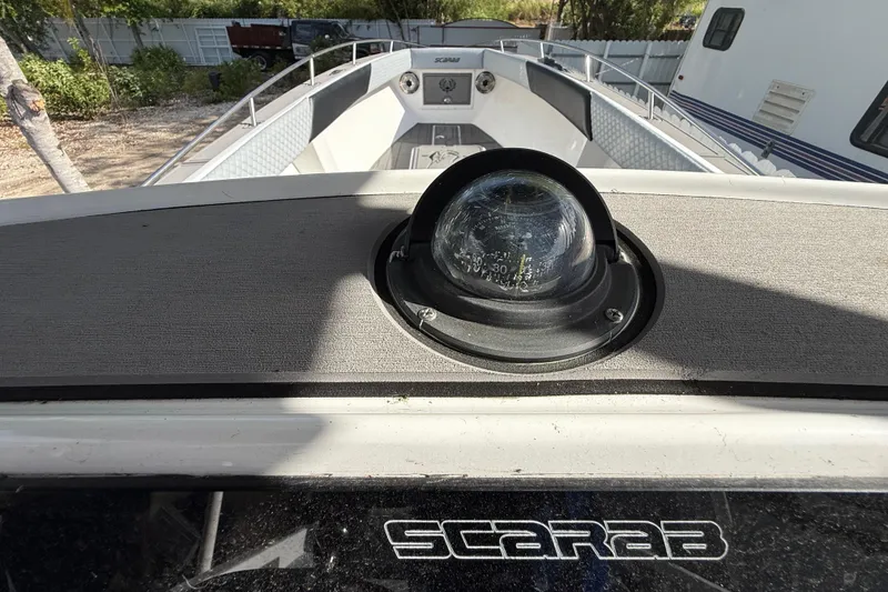 Slide: The Image of 1989 Wellcraft 302 Scarab boat with compass, docked outdoors. - 102