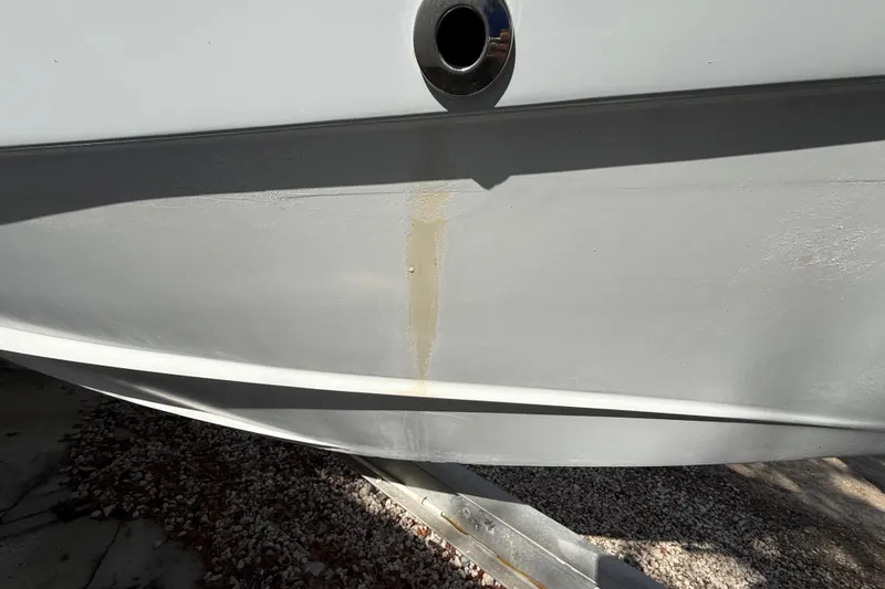 Slide: The Image of 1989 Wellcraft 302 Scarab boat hull with visible stain and metal fitting. - 120