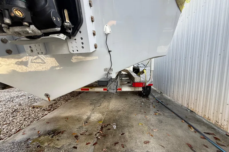 Slide: The Image of 1989 Wellcraft 302 Scarab boat on trailer, parked beside a metal building. - 16