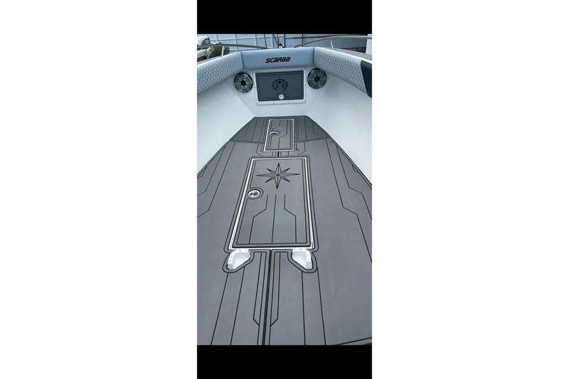 The Image of 1989 Wellcraft 302 Scarab boat on trailer, parked outdoors under a bright sky. - 2