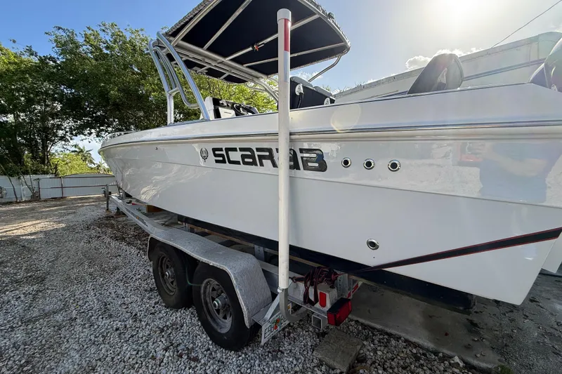 Slide: The Image of 1989 Wellcraft 302 Scarab boat on trailer, parked outdoors under sunlight. - 20