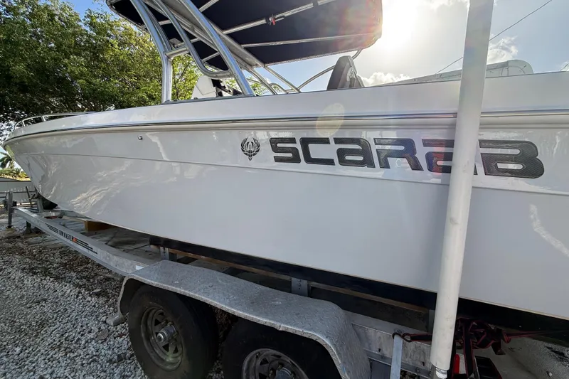 Slide: The Image of 1989 Wellcraft 302 Scarab boat on trailer, side view with logo visible. - 21