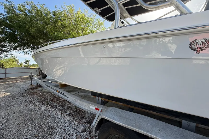 Slide: The Image of 1989 Wellcraft 302 Scarab boat on trailer, side view with trees in background. - 22