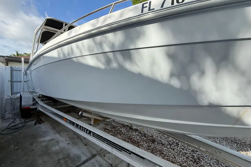 Slide: The Image of 1989 Wellcraft 302 Scarab boat on trailer, side view under clear sky. - 32