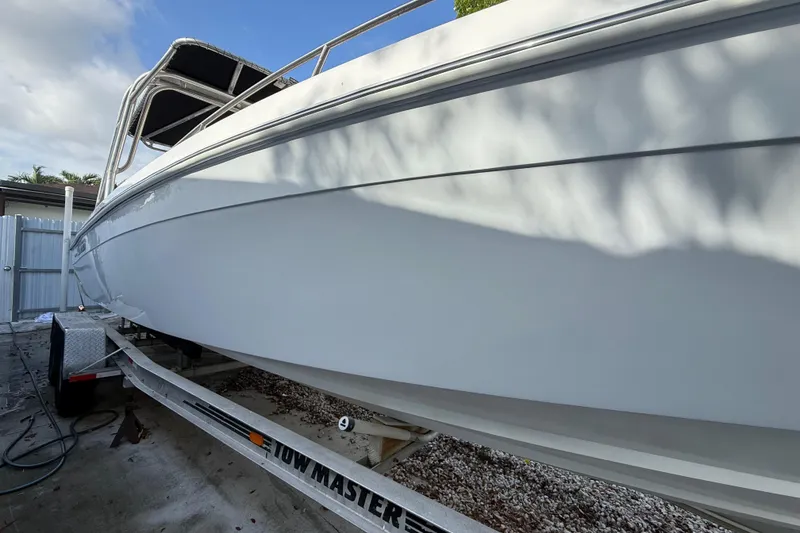 Slide: The Image of 1989 Wellcraft 302 Scarab boat on trailer, side view under clear sky. - 33
