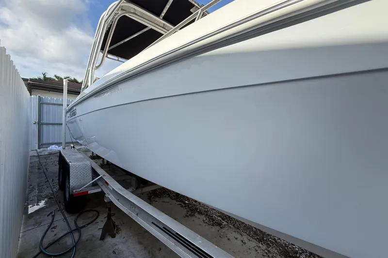 Slide: The Image of 1989 Wellcraft 302 Scarab boat on trailer, side view, parked outdoors. - 34