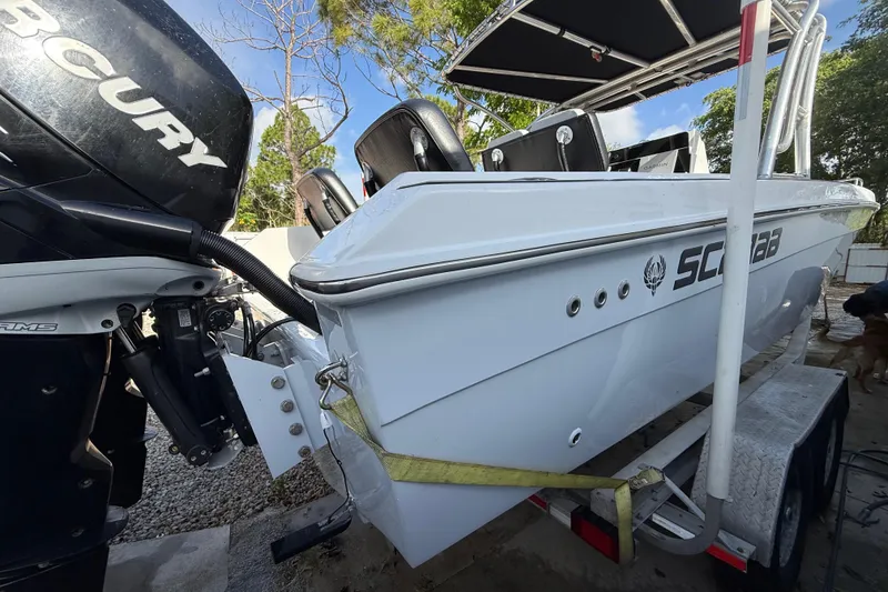 Slide: The Image of 1989 Wellcraft 302 Scarab boat on trailer, featuring Mercury outboard engine. - 39