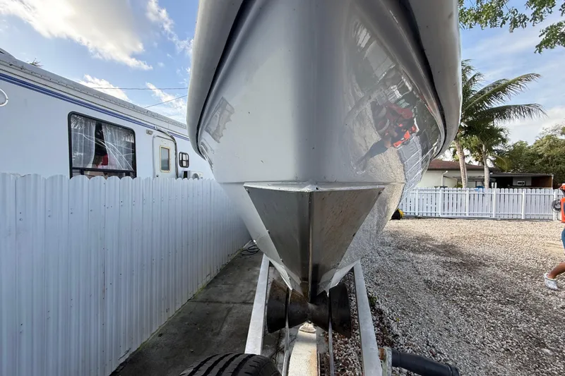 Slide: The Image of 1989 Wellcraft 302 Scarab boat on trailer, parked beside a white fence and RV. - 40