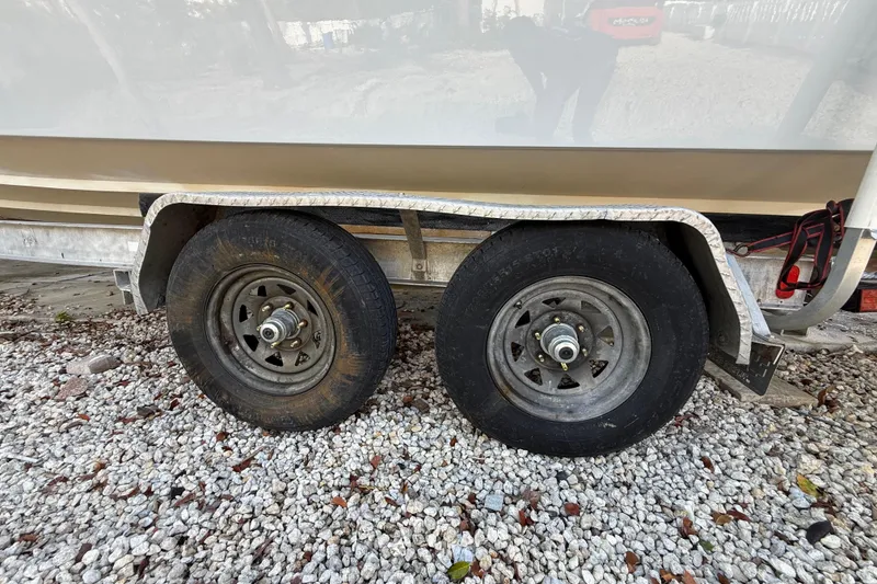 Slide: The Image of Trailer wheels of a 1989 Wellcraft 302 Scarab on gravel surface. - 42