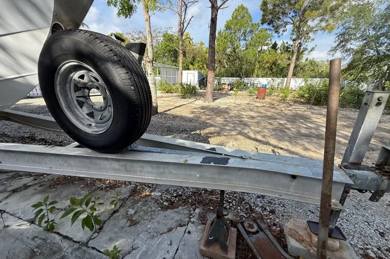Slide: The Image of Trailer with spare tire for 1989 Wellcraft 302 Scarab, parked on gravel. - 43