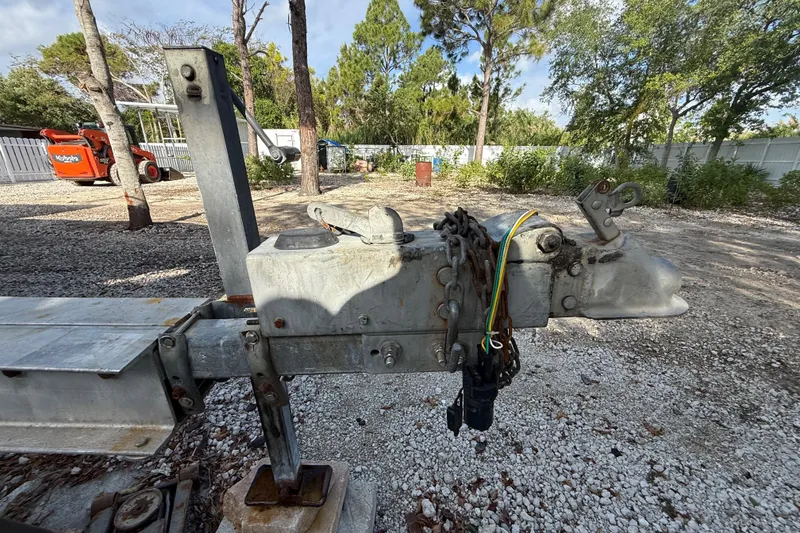 Slide: The Image of Trailer hitch of a 1989 Wellcraft 302 Scarab, surrounded by trees and gravel. - 44