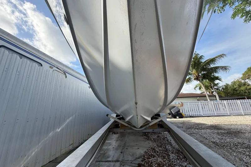 Slide: The Image of 1989 Wellcraft 302 Scarab boat hull on trailer, outdoor storage, sunny day. - 46