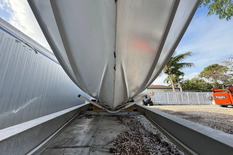 Slide: The Image of 1989 Wellcraft 302 Scarab boat hull on trailer, outdoor storage setting. - 47