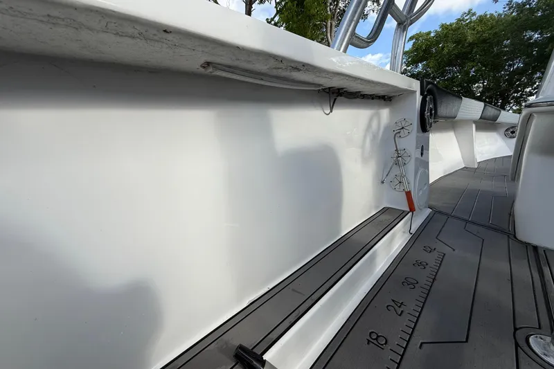 Slide: The Image of 1989 Wellcraft 302 Scarab boat deck with measurement markings and fishing rod holders. - 75