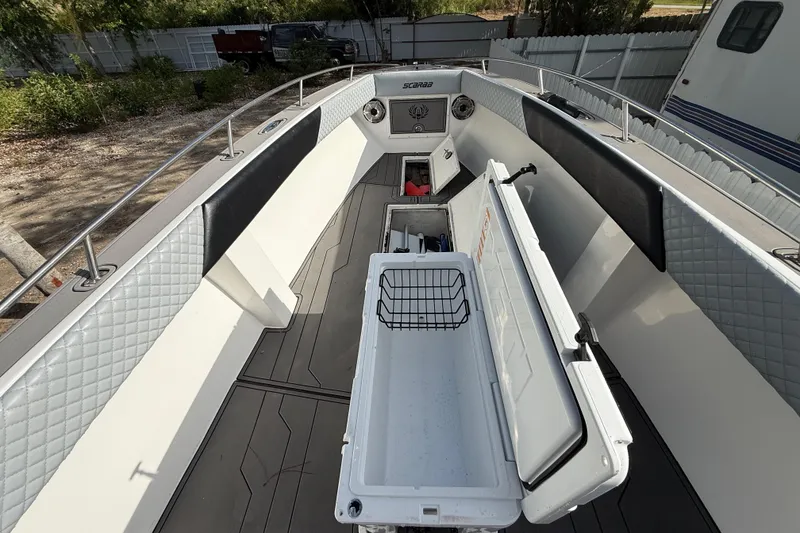 Slide: The Image of 1989 Wellcraft 302 Scarab boat interior with open storage compartments and quilted upholstery. - 90