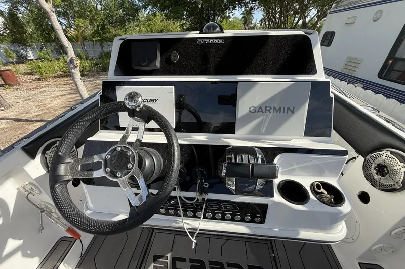 Slide: The Image of 1989 Wellcraft 302 Scarab boat dashboard with Garmin and Mercury controls. - 93