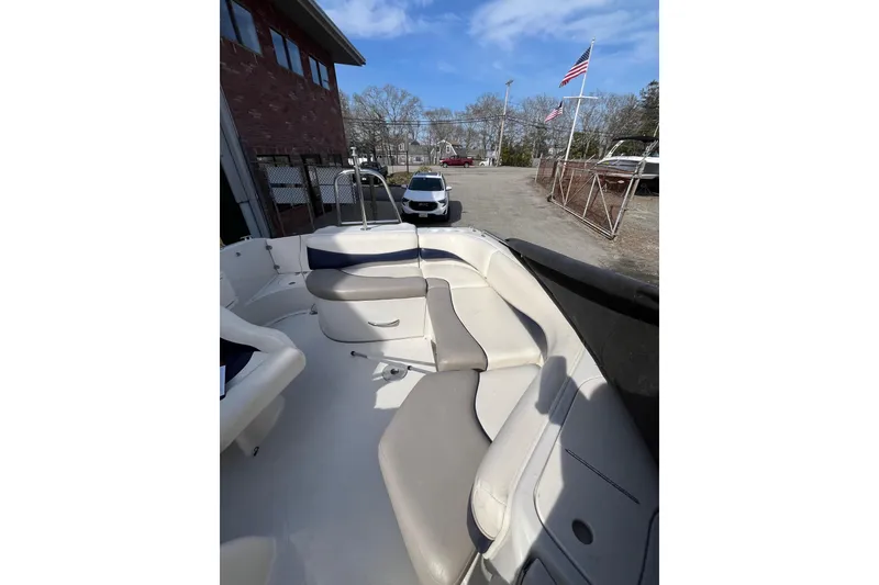 Slide: The Image of 2006 Tahoe 222 boat interior with seating, parked outdoors under a clear sky. - 12
