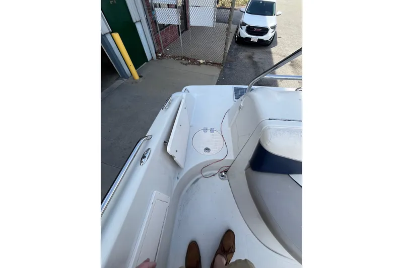 Slide: The Image of 2006 Tahoe 222 boat interior with docked view and parked car nearby. - 13