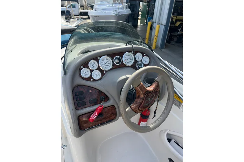 Slide: The Image of Steering console of a 2006 Tahoe 222 boat with gauges and controls. - 15
