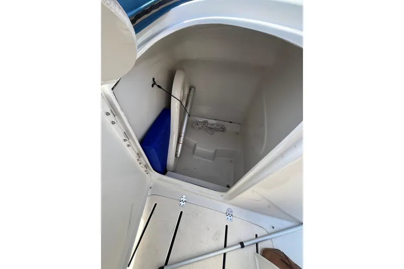 Slide: The Image of Storage compartment in a 2006 Tahoe 222 boat, featuring a life preserver and rope. - 19