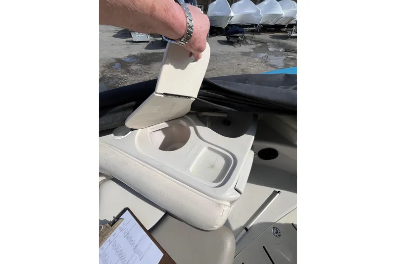 Slide: The Image of 2006 Tahoe 222 boat interior with storage compartment open, revealing cup holder. - 23