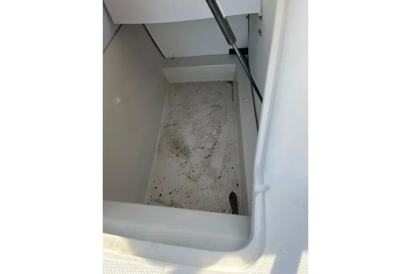 Slide: The Image of Storage compartment of a 2006 Tahoe 222 boat, showing interior space and slight dirt. - 25